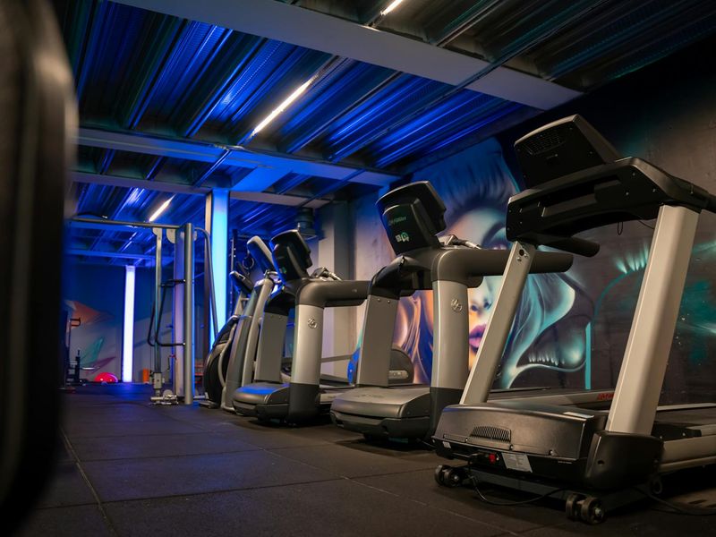 Minimalist gym interior with neon blue lighting accents.